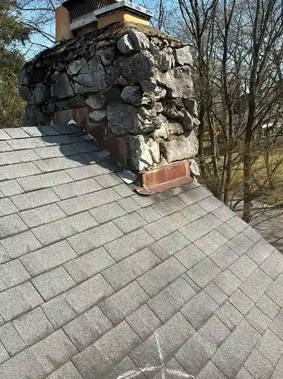 Completed counter flashing repair on natural stone chimney
