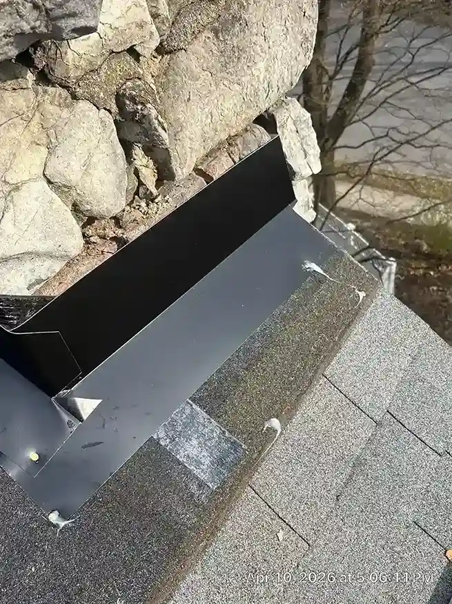 Stone chimney base detail with new metal flashing