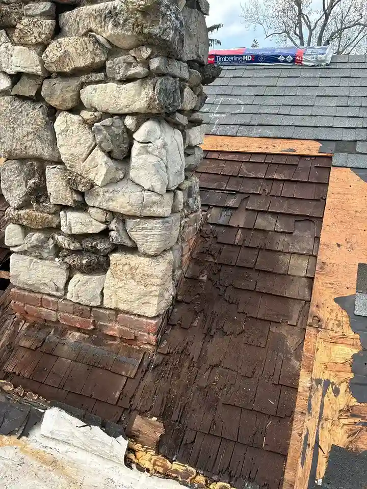 Stone chimney renovation with exposed underlayment