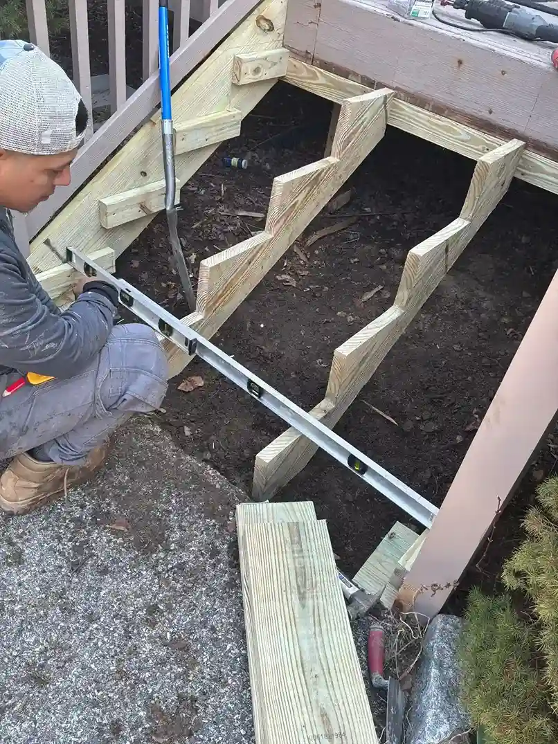 Old weathered grey deck boards contrasted with newly built stairs