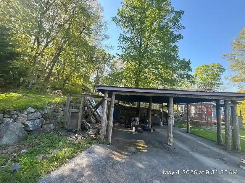 Rustic wood pavilion with log posts and stone retaining wall