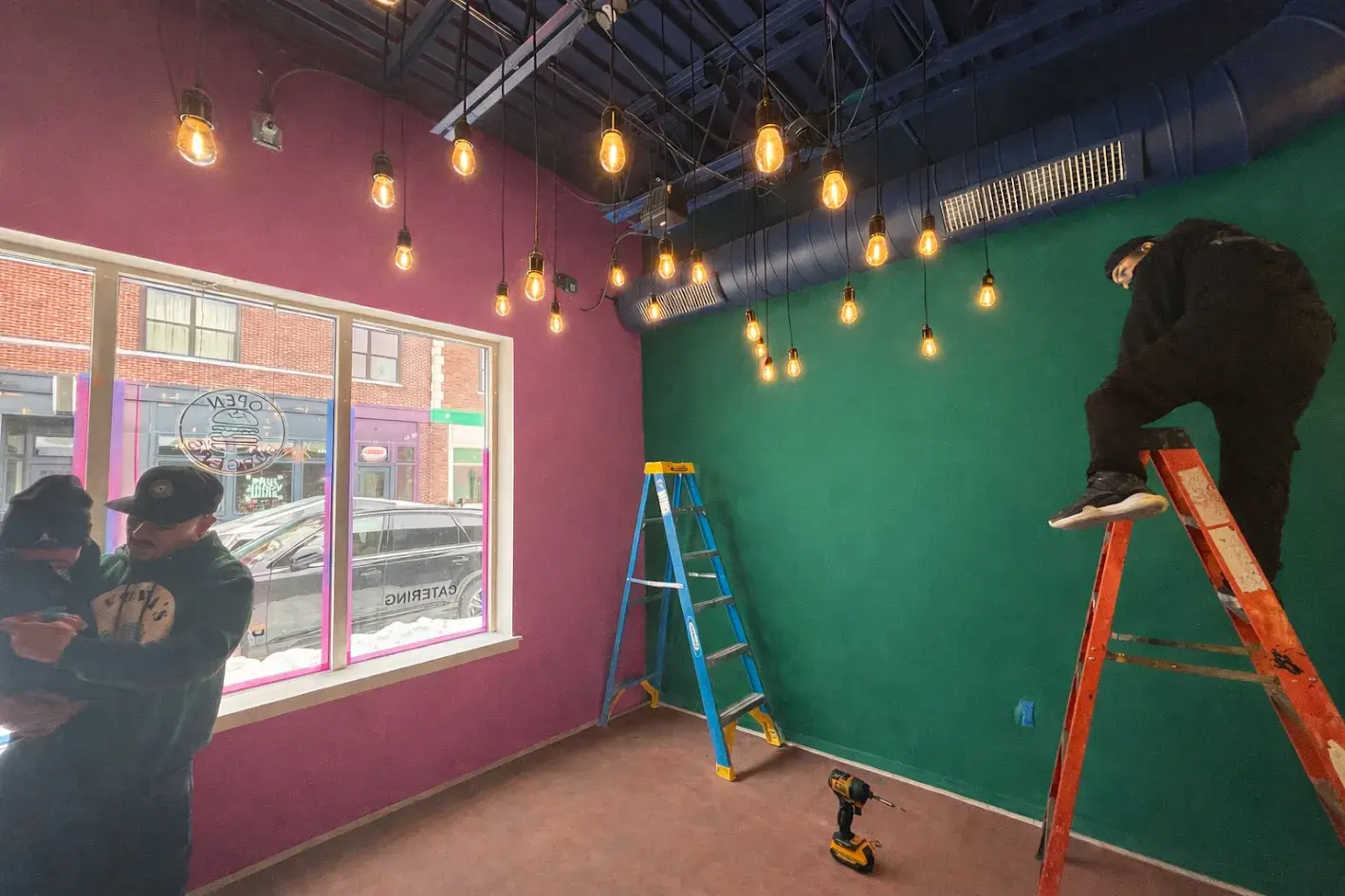 Workers painting commercial restaurant walls purple and green