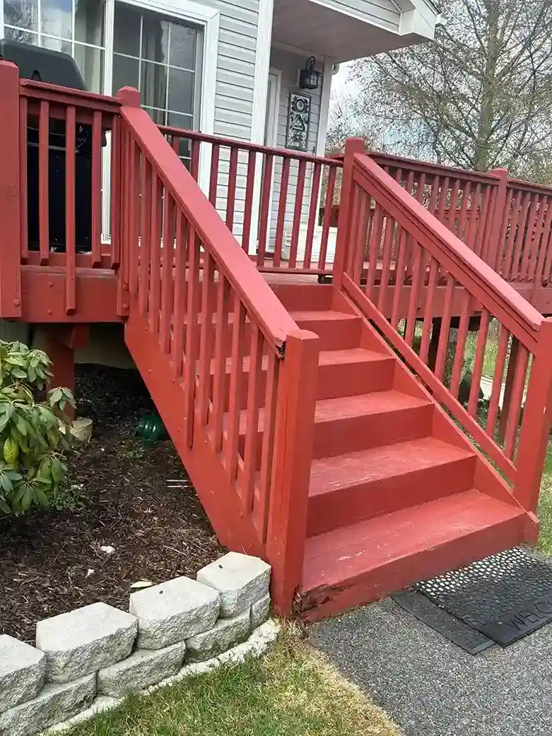 Freshly painted red deck stairs with clean vertical balusters