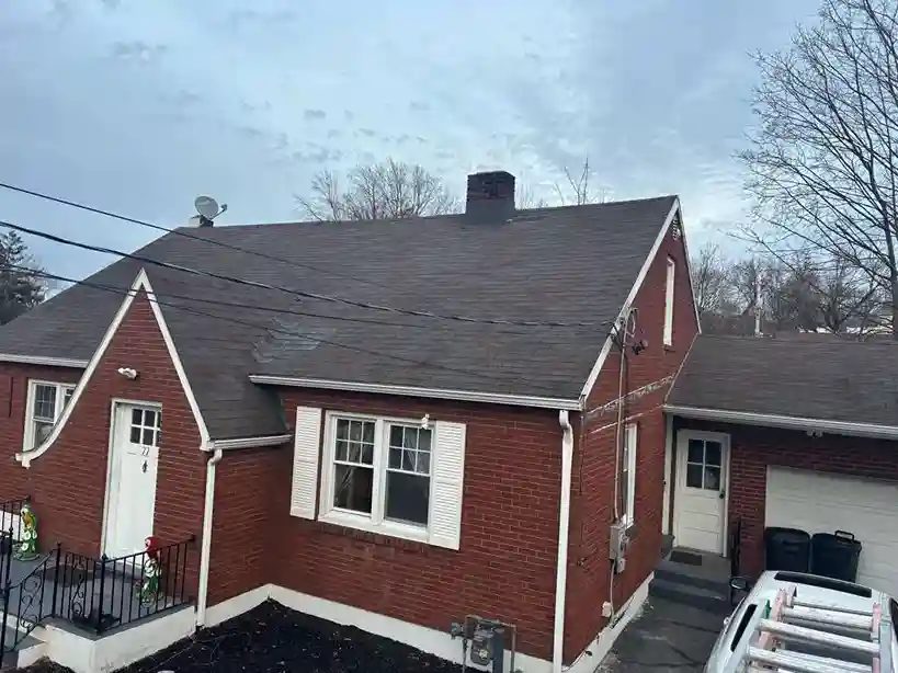 Applying ridge cap shingles along a roof peak line
