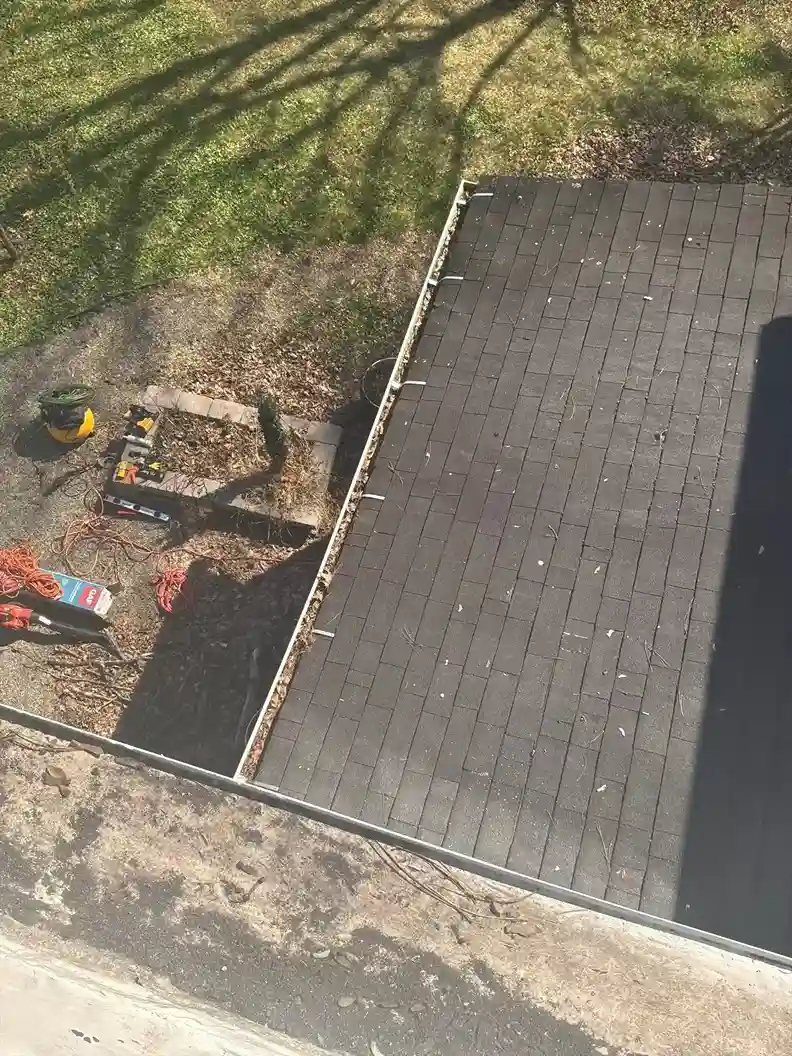 Inspecting storm-damaged shingles on residential roof